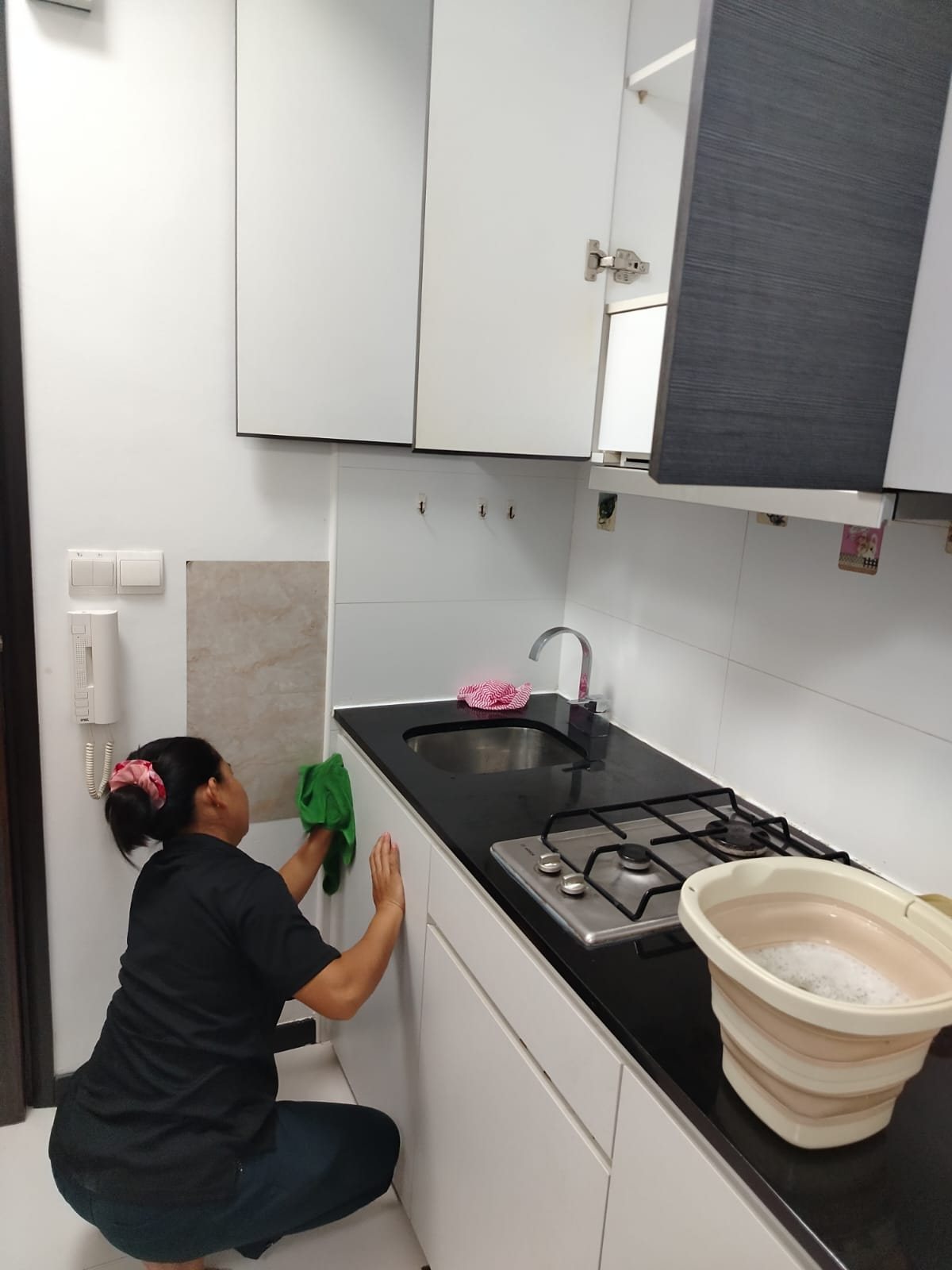 Home cleaner wiping kitchen cabinets